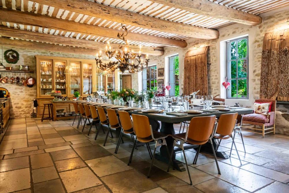 The long indoor dining table under beamed ceilings and stone walls