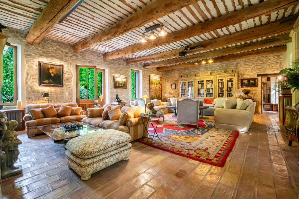 The library, with bookcases, armchairs and a terracotta floor